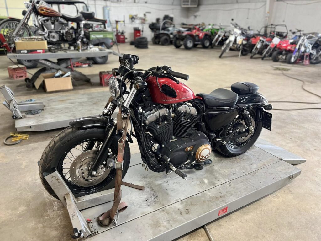 Red and black Harley-Davidson motorcycle on a shop lift